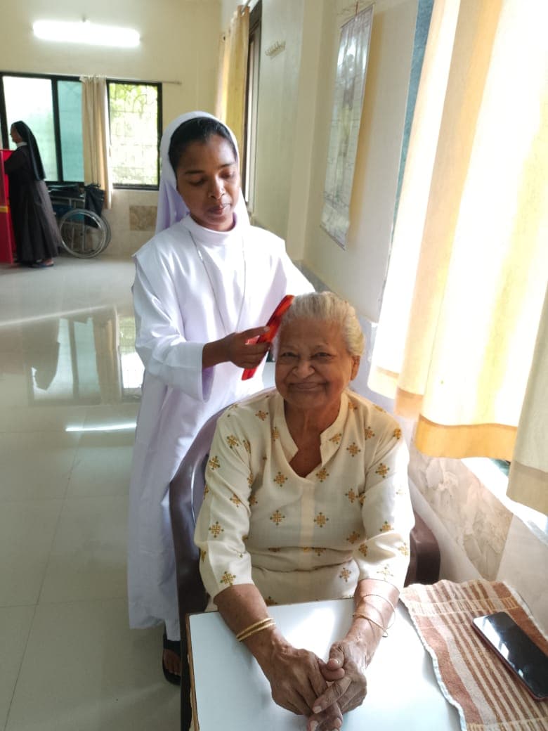Elderly residents sharing a quiet memory-filled moment with a sister.