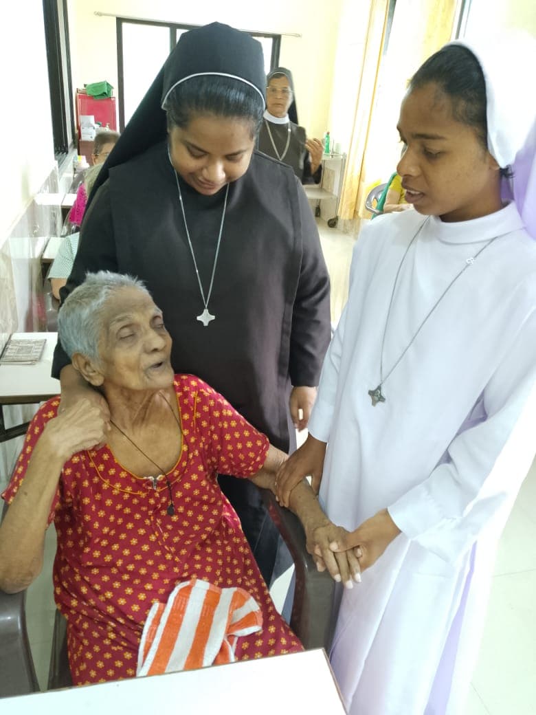 A caring moment with elderly residents and a sister at the old age home.